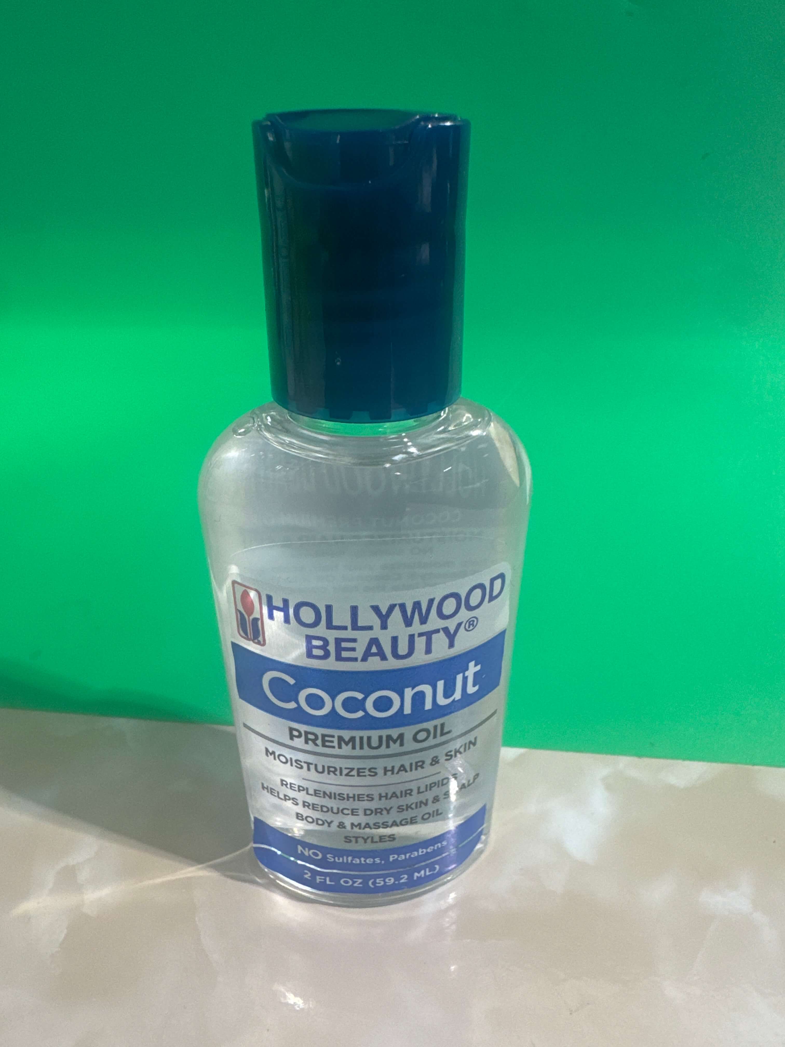 Bottle of Hollywood Beauty Coconut Premium Oil on a green background